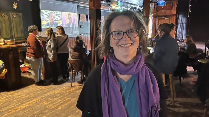 Vicky Brazeau est debout dans une salle pour se faire prendre en photo.  