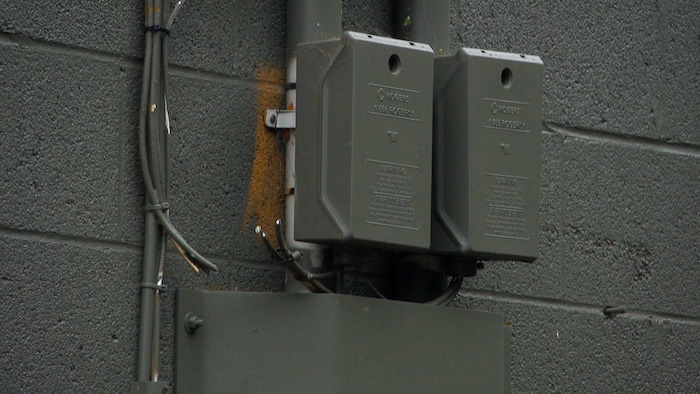 Trois fils électriques coupés, le long d'un mur extérieur du bâtiment.