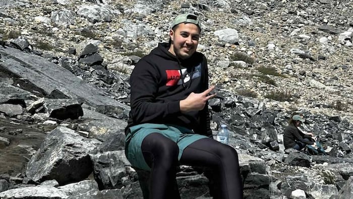 Hamza Benhilal lors d'un voyage photographié au milieu d'un paysage rocheux.