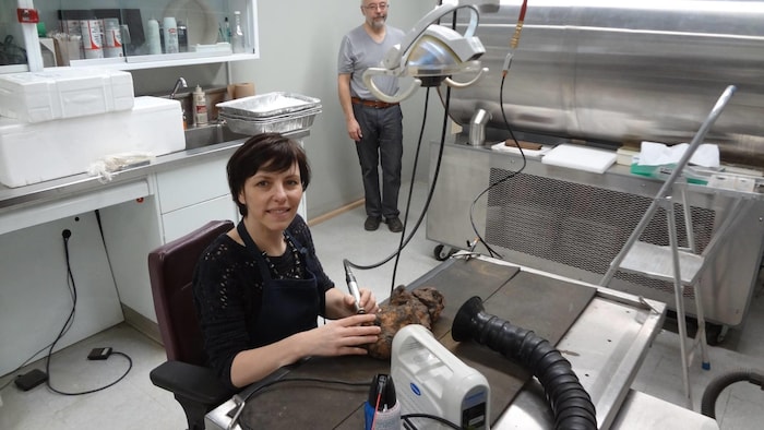 Deux personnes dans un laboratoire regardent la caméra.