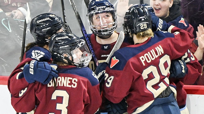 Des joueuses de hockey célèbrent un but.