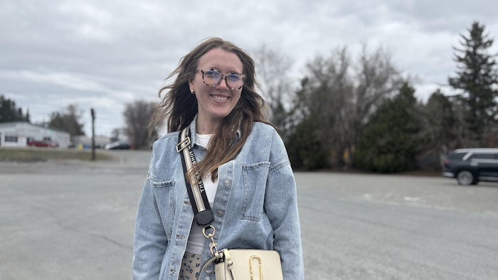 Portrait de Victoria Kennedy, les cheveux poussés en arrière par le vent qui sourit à la caméra.