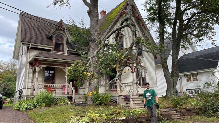 Un homme devant une vieille maison.