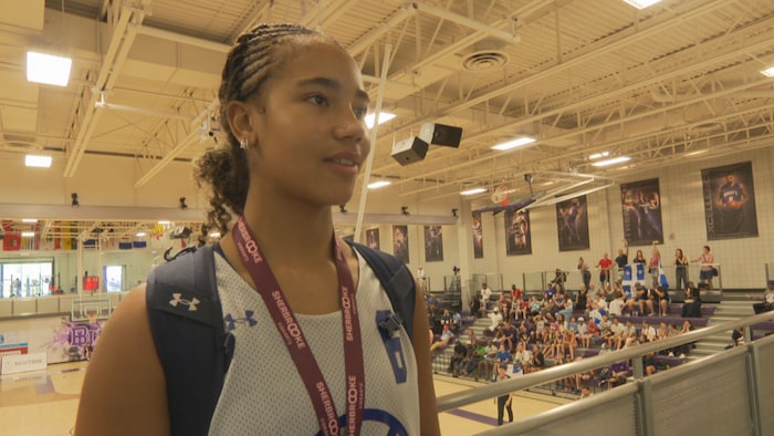 Victorya Stephen en entrevue devant un terrain de basket. 