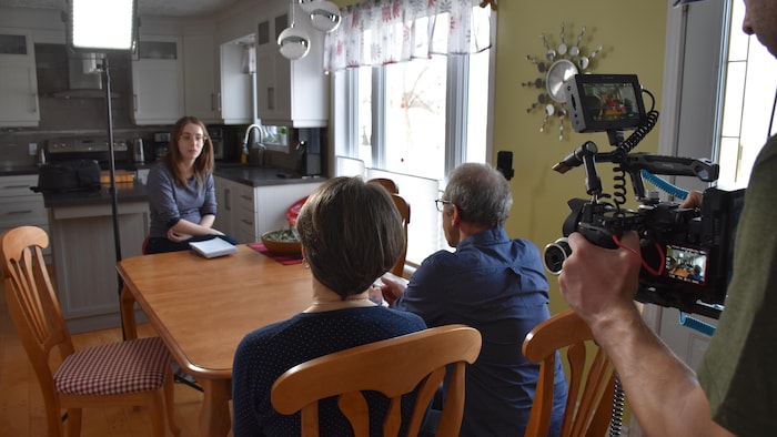 La journaliste Rosalie Dumais-Beaulieu discute avec deux personnes.