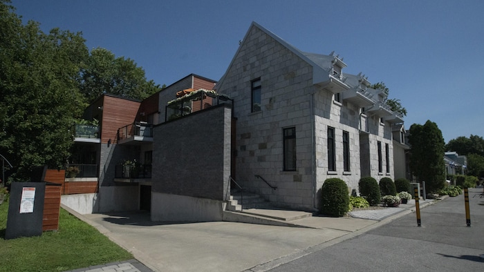 Une entrée de stationnement derrière une maison aux allures patrimoniales.