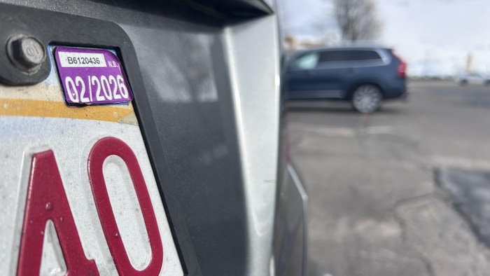 Gros plan sur une vignette collée sur une plaque d'immatriculation.