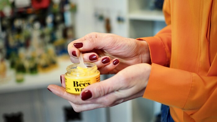  Viktoriia Maslovka tient un pot de crème ouvert dans les mains.      