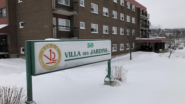 Façade de l'édifice et affiche de la Villa Des Jardins.