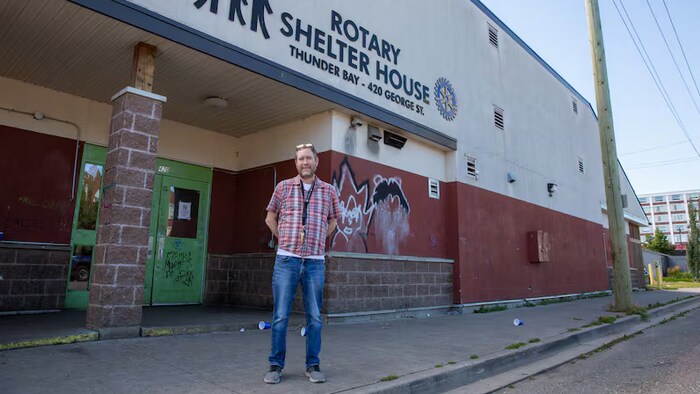 Un homme debout devant un refuge à Thunder Bay.