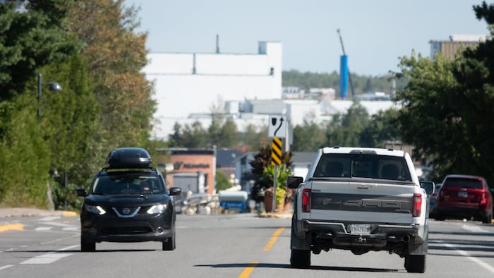 Des véhicules se déplacent sur une route en ville.