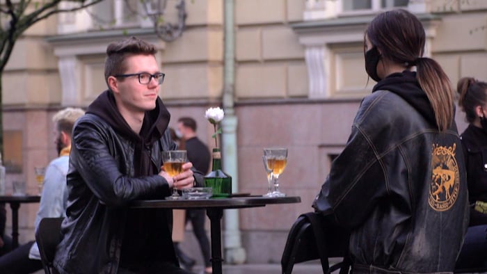 Un couple assis à une table en extérieur.