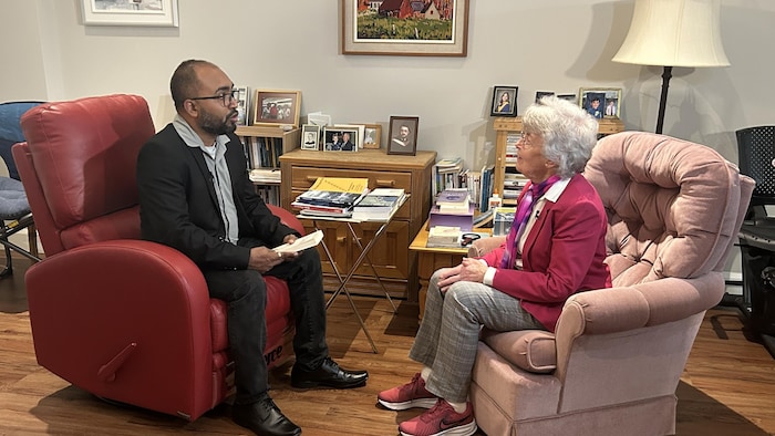 Vimal Parmar et Fernande Cantin discutent assis sur des fauteuils dans un salon.