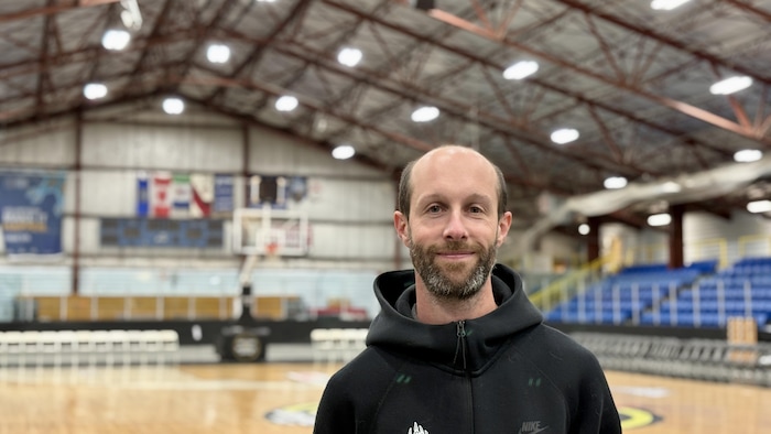 Vincent Bonnay sourit devant le terrain de basketball installé à l'aréna Takhini spécialement pour l'événement.