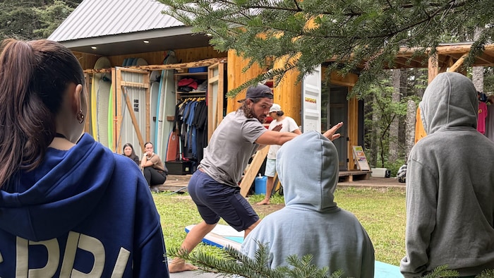 Vincent Marticotte montre aux jeunes comment se lever sur la planche.