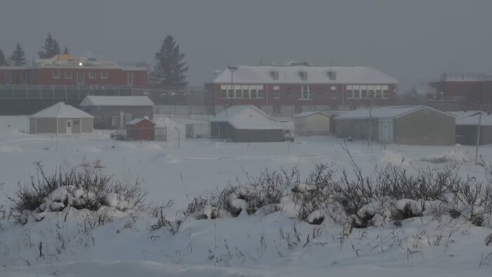 Des maisons entourées de tas de neige.
