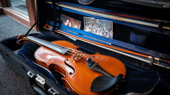 Une photo de Richard Desjardins entouré d'enfants et d'Angèle Dubeau dans un étui de violon.