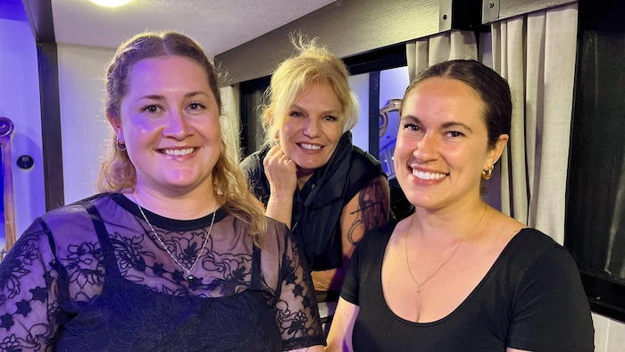 Élie-Anne, Valérie et Noémie posent dans une roulotte en coulisses du festival Osisko en lumière.