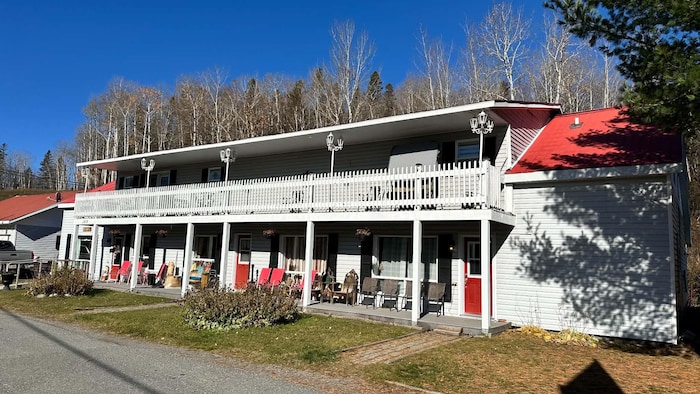 Façade d'une auberge à deux étages avec un grand balcon.
