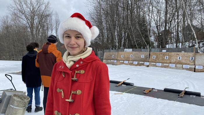 Une femme devant un champ de tir de biathlon. 