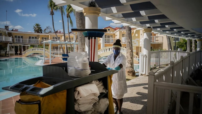 Wearing a mask against the spread of the new coronavirus, a maid goes to clean the rooms at the Hotel Comodoro in Havana, Cuba, Thursday, Feb. 11, 2021.
