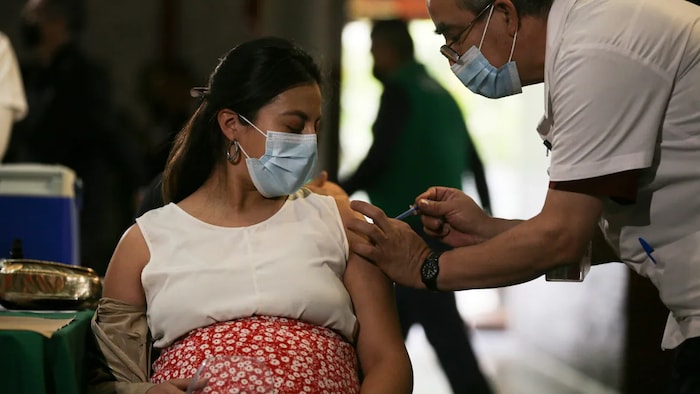 A pregnant woman gets a Pfizer vaccine shot for COVID-19 at a library converted into a vaccination center in Mexico City on May 13, 2021.