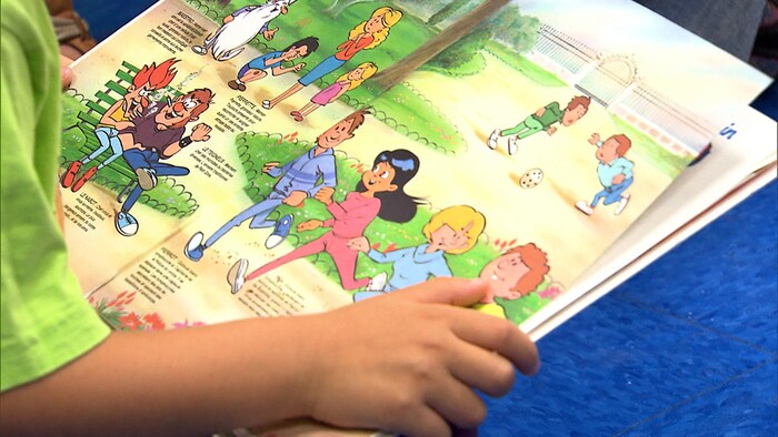 Un enfant regarde un livre illustré.