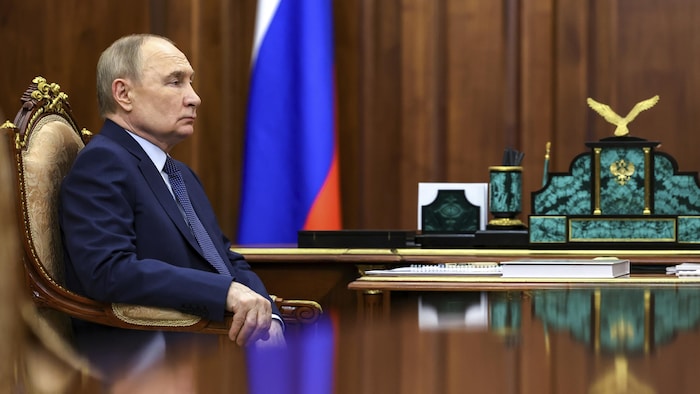 Vladimir Poutine assis.