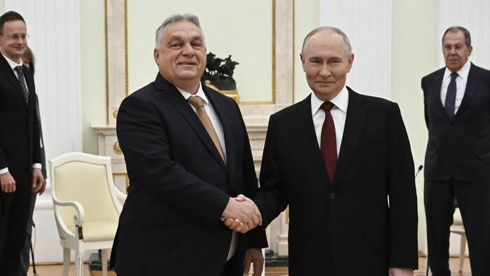 Vladimir Poutine et Viktor Orban se serrent la main.