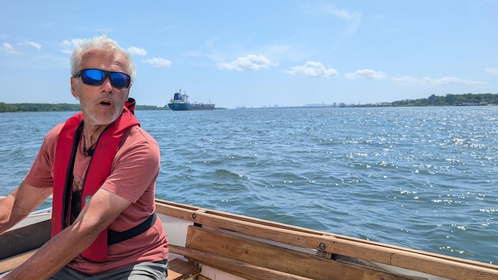 Un marin sur le fleuve avec Montréal en arrière-plan.