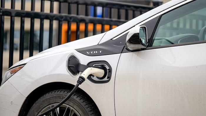 Une voiture électrique connecté à une source d'alimentation pour charger la batterie