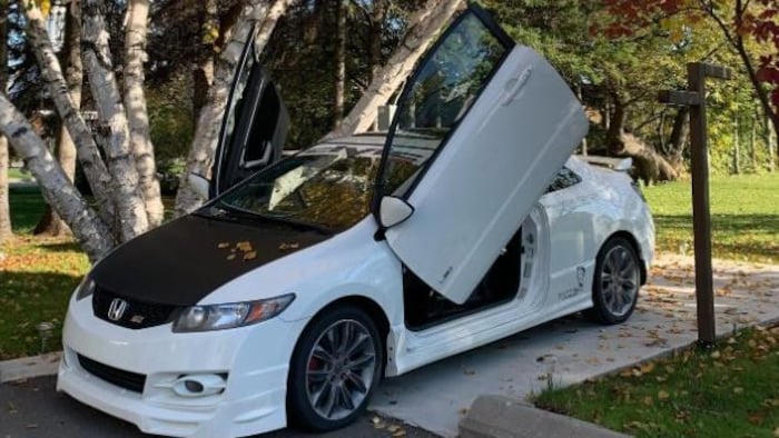 Une voiture blanche avec la porte ouverte.