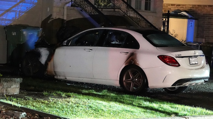 Un véhicule stationné dans une entrée privée qui a été ravagé par les flammes.
