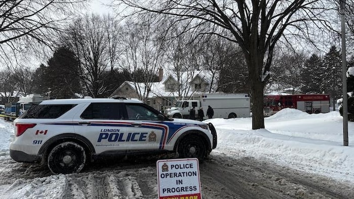 Une voiture de police devant la propriété située au 212, place Chesham, à London, en Ontario, où vivaient trois des accusés.