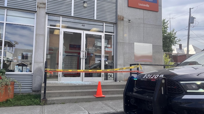 Un véhicule de police stationné devant un bureau de Postes Canada.
