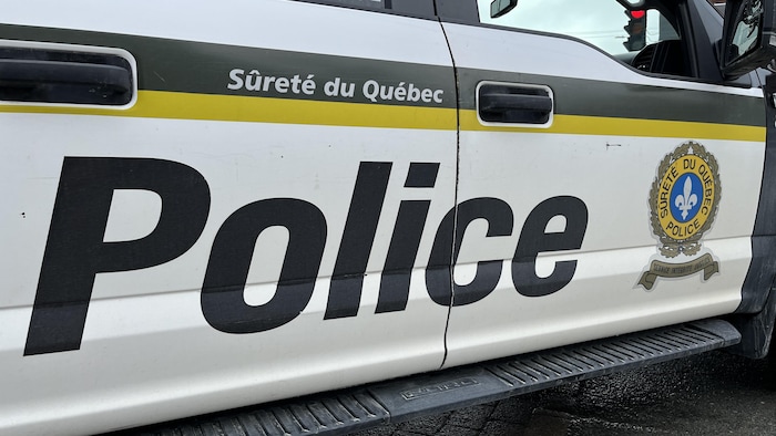 Une voiture de la Sûreté du Québec près d'un feu d'arrêt.