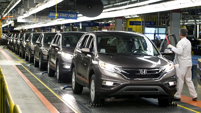 Un employé d'un fabricant automobile inspecte une chaîne de montage.