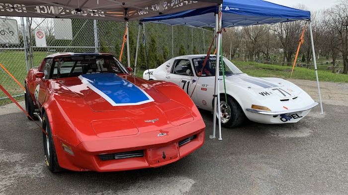 deux voitures de courses vintage, une rouge et une blanche