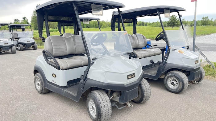 Des voiturettes de golf grises de marque Club Car.