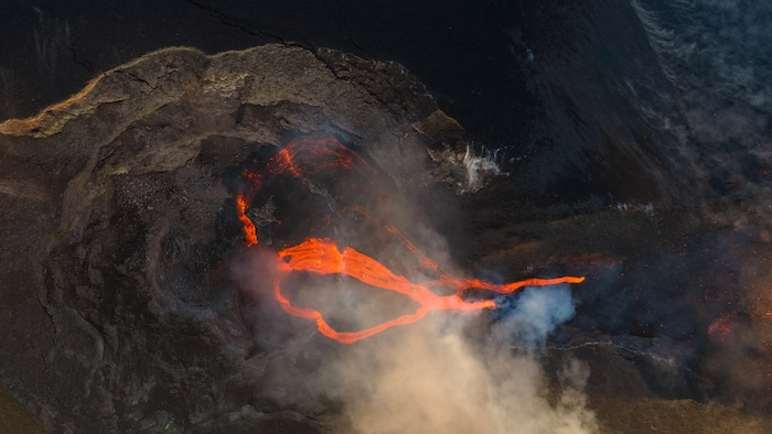 Une vue prise par drone montre de la lave en fusion s'écoulant d'un cratère.