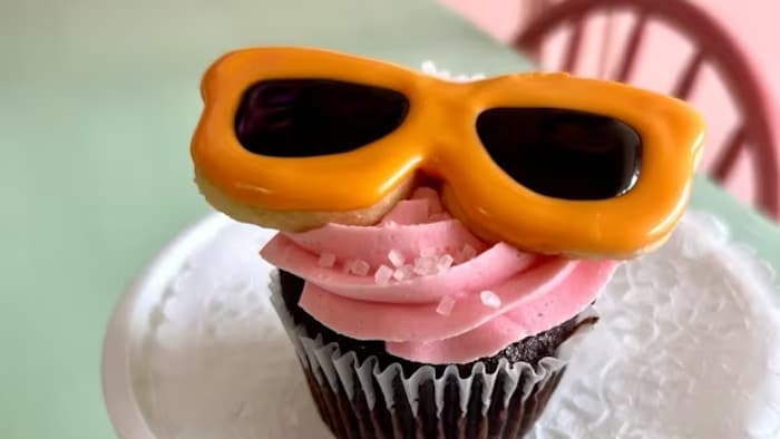 Un petit gâteau garni d'un biscuit en forme de paire de lunettes.