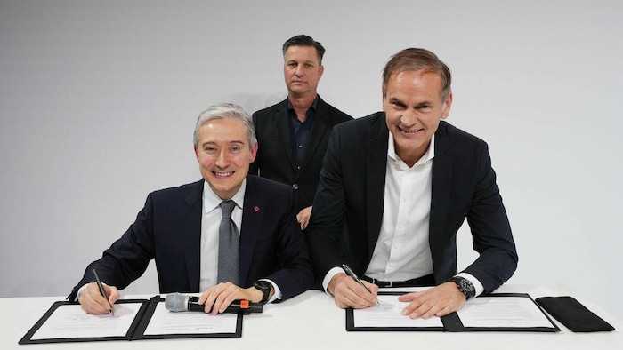 François-Philippe Champagne et Oliver Blume signent des documents sur une table.