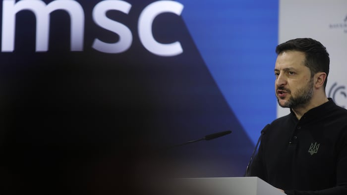 Il est debout derrière un lutrin.