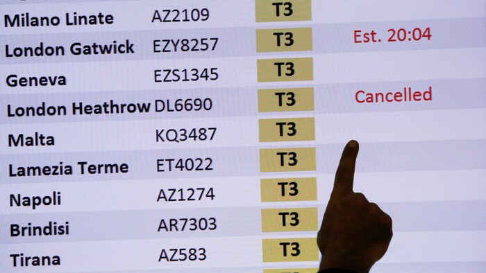 Un tableau des arrivées montre un vol annulé de Londres à l'aéroport de Fiumicino, en Italie. 