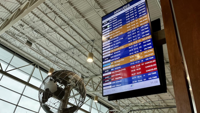 Un tableau des arrivées dans un aéroport montrant plusieurs vols retardés ou annulés.