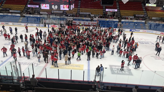Plusieurs personnes au centre d'une patinoire.