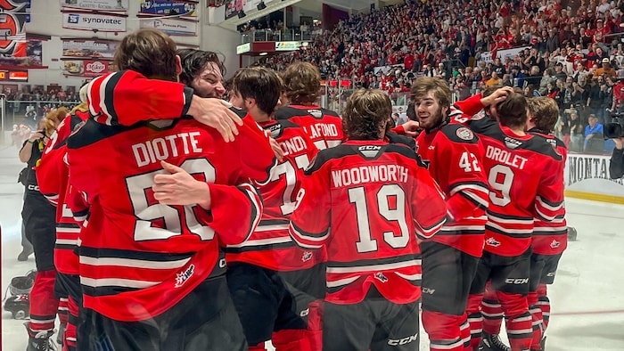 Des joueurs de hockey qui célèbrent sur la glace.
