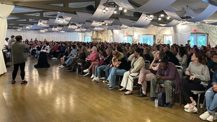 Une foule de femmes assises dans une salle lors d'une assemblée.