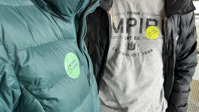 Gros plan sur des étudiants qui ont collé un collant « j'ai voté » sur leur chandail. 