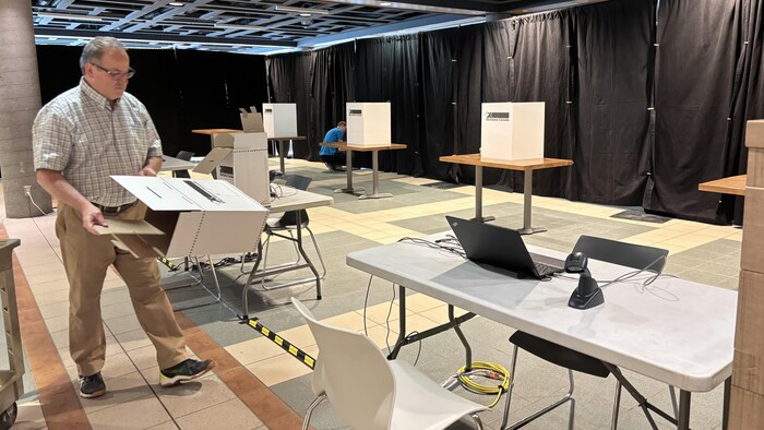 Un homme installe le bureau de vote.